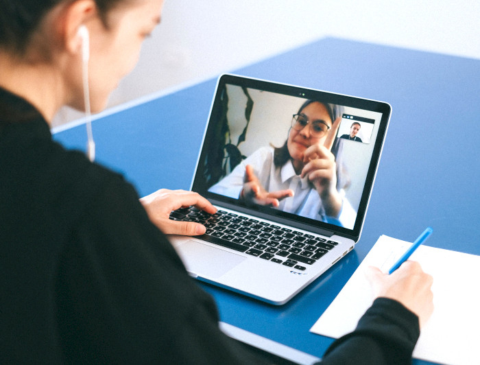 Student talking to another through a screen.