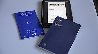 Libros impresos y digital en tablet de la propuesta constitucional.