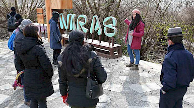 Grupo de personas frente a un cartel del Museo MIRAS