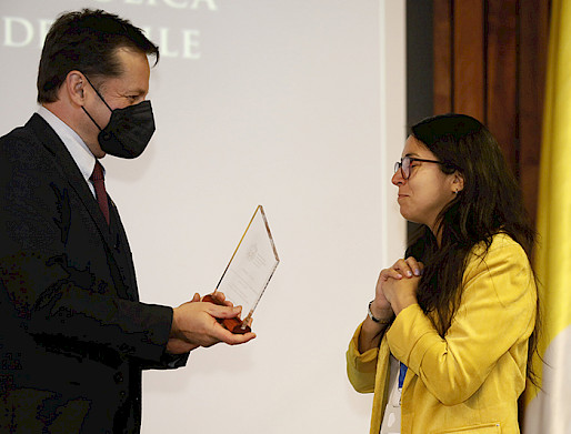 Paula Núñez recibiendo el galvano de parte de Pedro Bouchon, Vicerrector de Investigación.