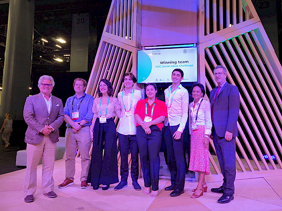 Reflush team is smiling in front of a screen that shows that they are the winners of the first version of the HUC Social Ideas Challenge.
