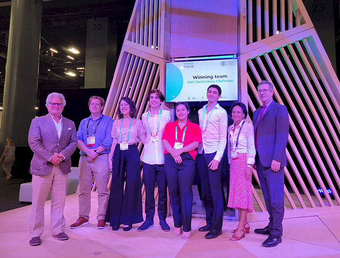 Reflush team is smiling in front of a screen that shows that they are the winners of the first version of the HUC Social Ideas Challenge.