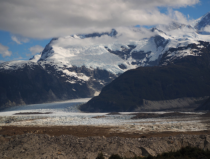 Exploradores Glacier is seen under a blue sky and a few clouds.