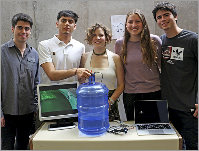 Grupo de estudiantes junto a un bidón de agua.