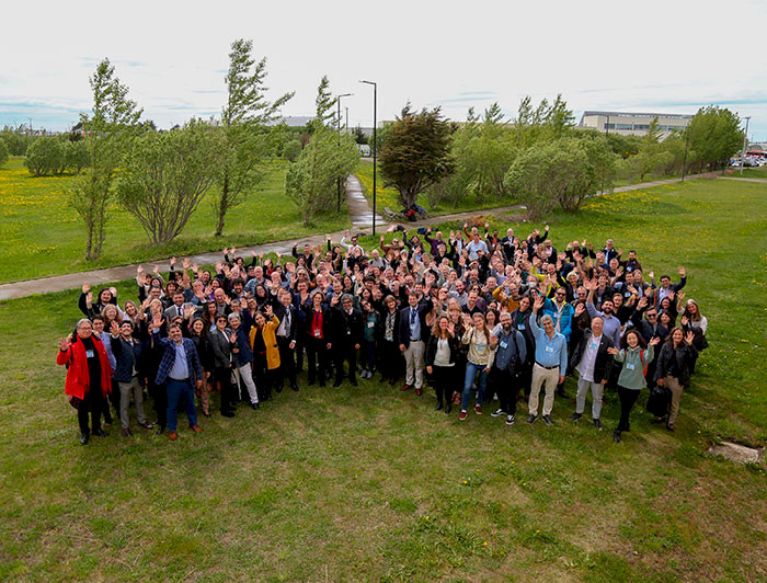 In Punta Arenas a big group of researchers from Sweden and Chile are smiling to the camera. The landscape is full of green trees and grass.