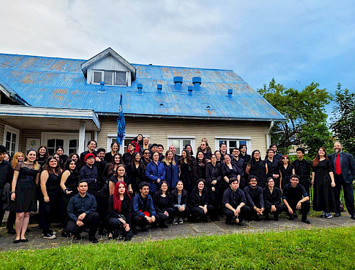 orquesta posando frente a una casa de madera