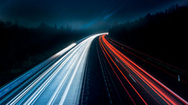 Carretera de noche con las luces de los autos en movimiento