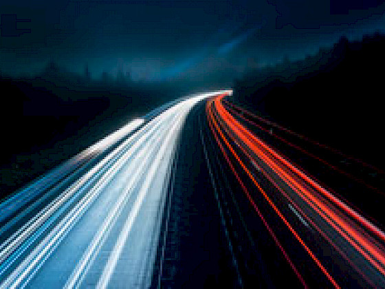 Carretera de noche con las luces de los autos en movimiento