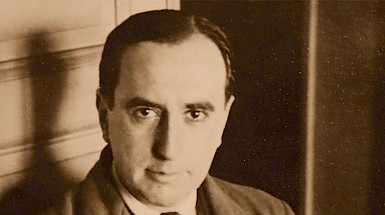 The Chilean writer and poet Vicente Huidobro is posing with a serious face. The photography is sepia.