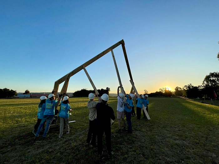 Personas levantando una estructura de madera.
