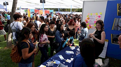 Grupo de estudiantes frente a un mesón de la Bienvenida Novata