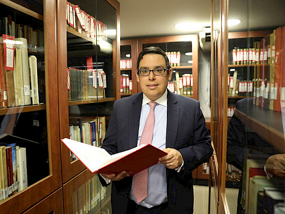 Professor Adolfo Wegmann amidst shelves full of books