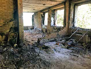 Remains of burned chairs in a destroyed and windowless room.