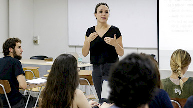 Profesora en una sala con estudiantes haciendo clases