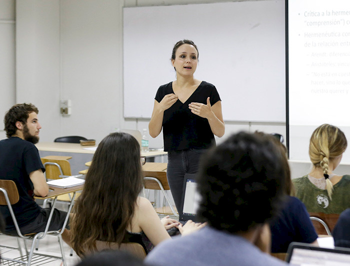 Profesora en una sala con estudiantes haciendo clases