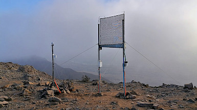 Un grupo de personas observa un neblinómetro en el desierto