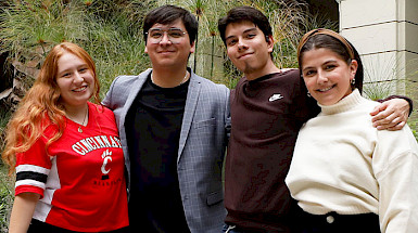 Los cuatro estudiantes becados de pie en un patio de Casa Central UC