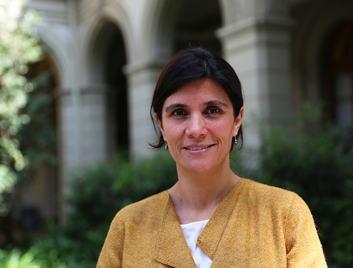 Fotografía de perfil de la profesora Francisca Reyes en patio de Casa Central UC