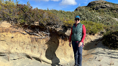 Woman posing in front of a cut on a hill.