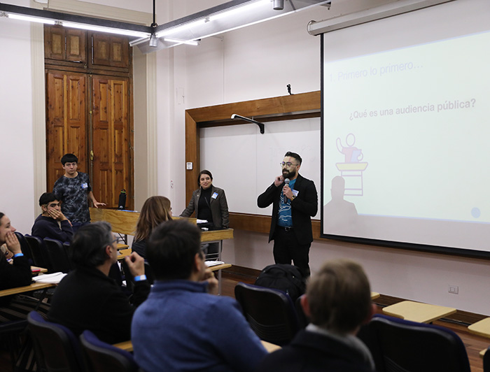 Persona explicando en una sala en qué consisten las audiencias públicas