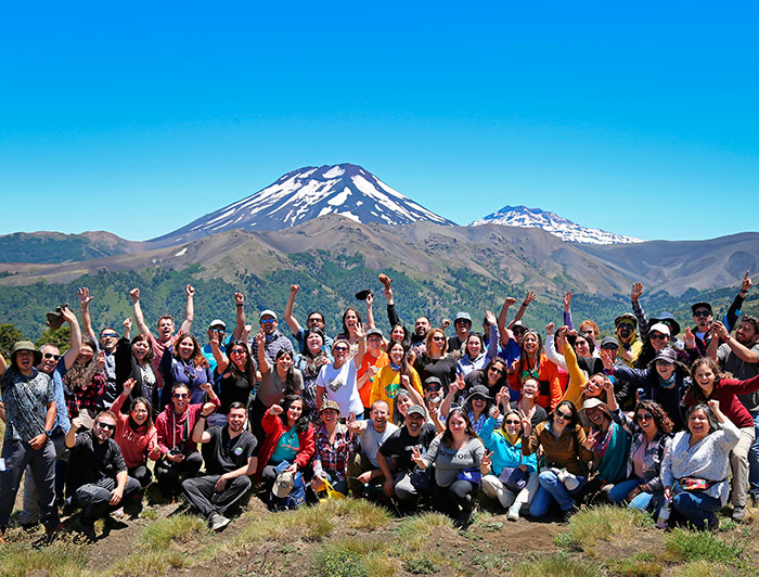 Grupo de personas con un volcán de fondo