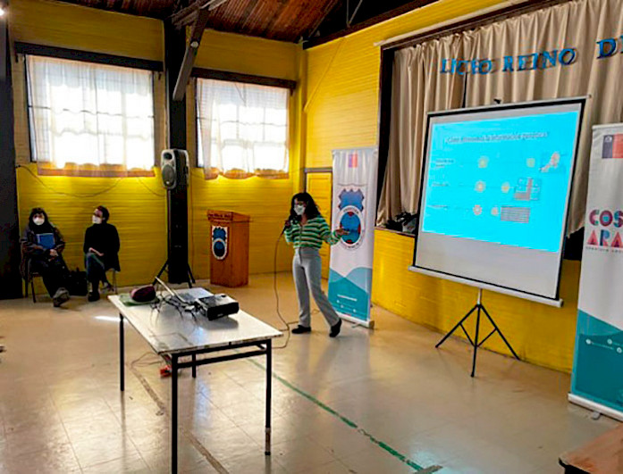 A woman presenting in a room.