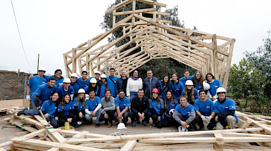 Grupo de personas frente a una capilla a medio construir.