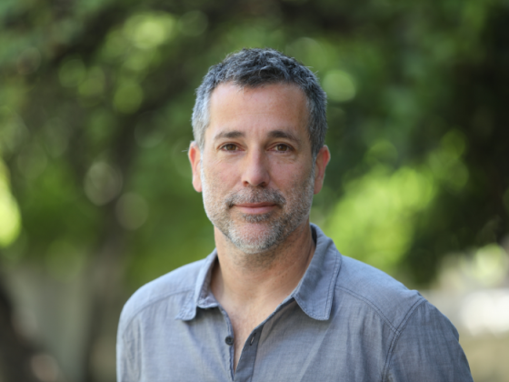 Christian Berger smiling. The background is green and blurry.