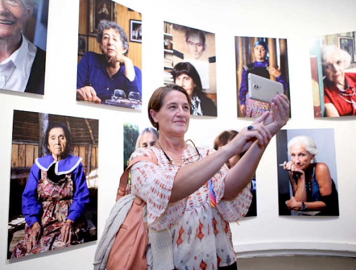 Mujer fotografiando la exposición de Atrevidas. 