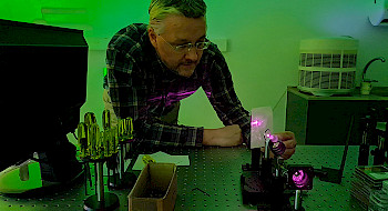Profesor Birger Seifert trabajando con equipo óptico.