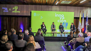 Expositores en el escenario frente al público en el lanzamiento del libro Innovación en la UC: 100 casos de alto impacto