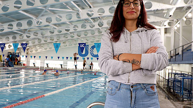 Fotografía de la estudiante Natalia Gutiérrez a un costado de la piscina del Campus San Joaquín UC.