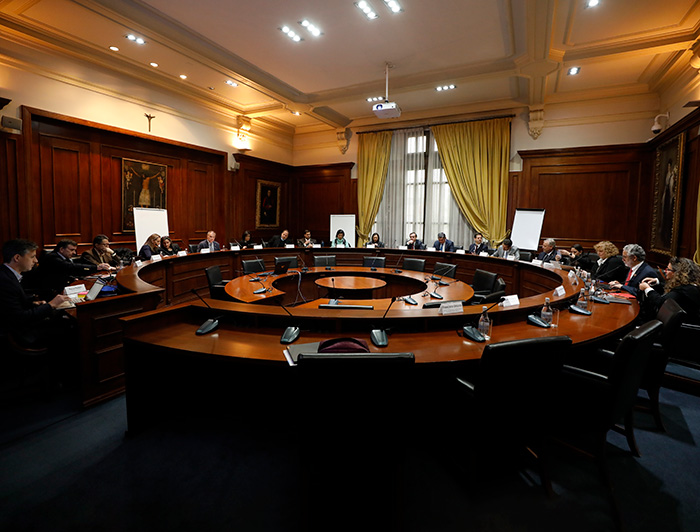 Reunión de trabajo de La Tríada en que los participantes se encuentran sentados en una mesa circular.
