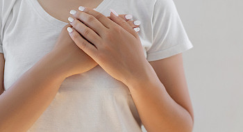 Una mujer cruza sus manos sobre su pecho