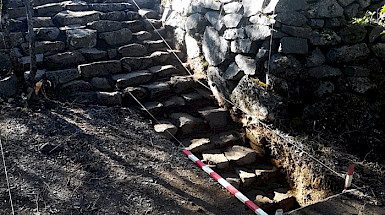 Restos arqueológicos de un muro y escalera de piedra