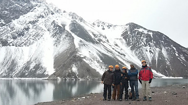 Grupo de investigadores usando cascos y ropa de terreno en el embalse el Yeso, en el Cajón del Maipo.