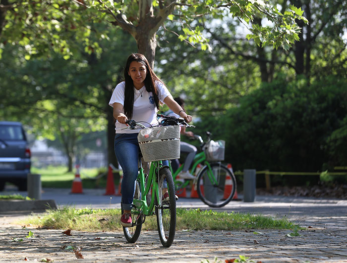 A young woman rides a bicycle on the San Joaquin Campus.