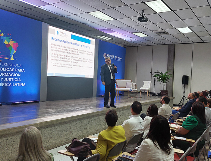 El académico Ernesto Treviño sobre un escenario exponiendo su trabajo frente al público durante el seminario.