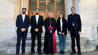 cinco personas de pie frente a una puerta