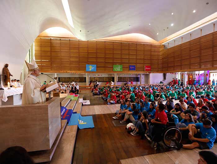 Monsignor Alberto Lorenzelli leading a Mass in a chapel with volunteers