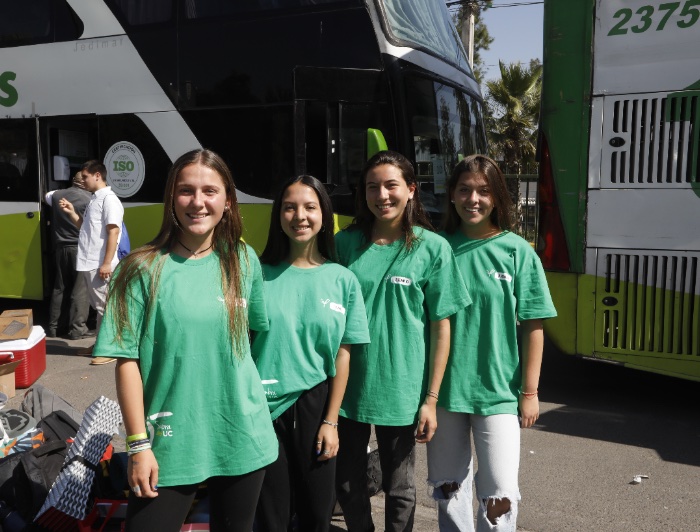 Cuatro voluntarias de misiones y trabajos delante de dos buses.