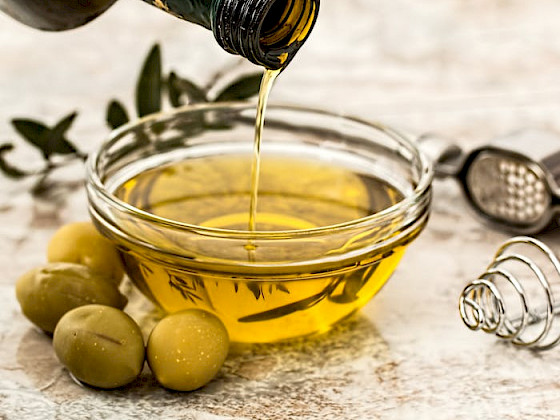 aceite de oliva siendo servido en un recipiente de vidrio