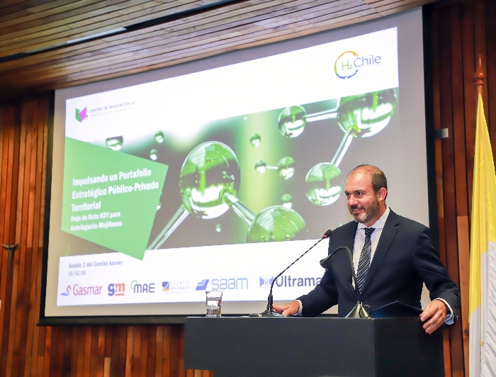 Ramón Molina, director ejecutivo del Centro de Innovación UC, hablando desde un podio con una presentación sobre la iniciativa de hidrógeno verde de fondo.