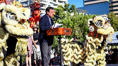Rector UC Ignacio Sánchez hablando en un escenario junto a dos figuras representativas de un león Durante la celebración del Año Nuevo Chino.