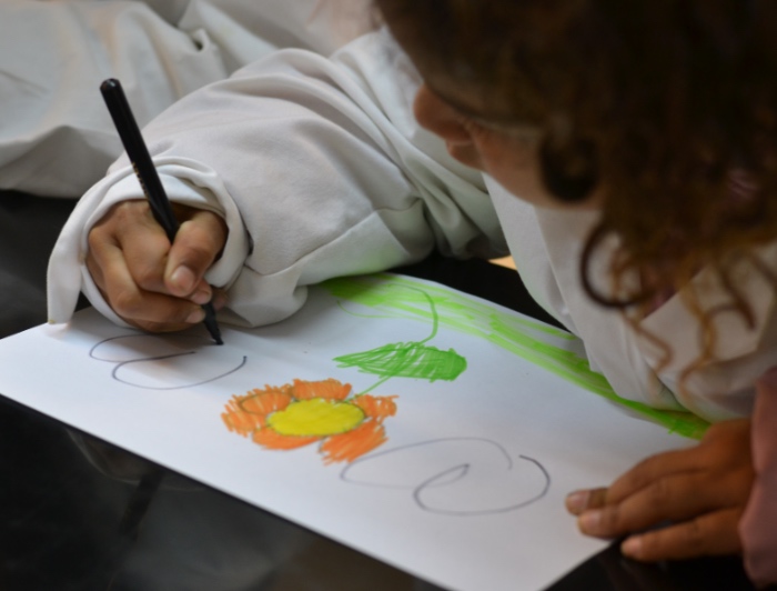 Niña pequeña dibuja una flor