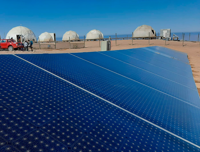 Set of blue solar panels. Behind you can see white domes.