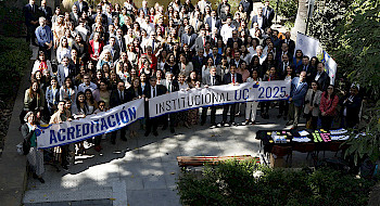 Fotografía de un grupo de personas en un patio de la UC sosteniendo lienzos de Acreditación Institucional UC 2025.