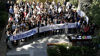 Fotografía de un grupo de personas en un patio de la UC sosteniendo lienzos de Acreditación Institucional UC 2025.