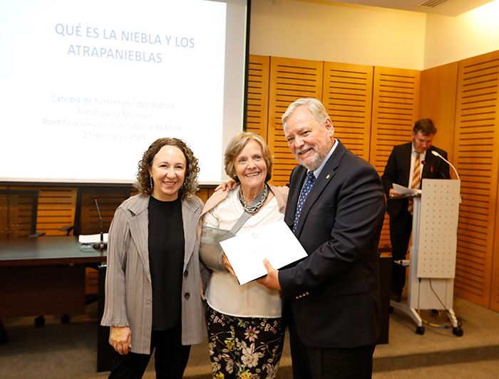 La profesora Pilar Cereceda (al centro) recibiendo un diploma junto a la decana de la Facultad de Historia, Geografía y Ciencia Política Valeria Palanza, y el prorrector de Gestión Institucional Patricio Donoso.