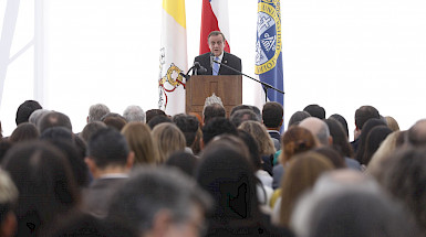 Rector Ignacio Sánchez dando su discurso en un podio frente al público.